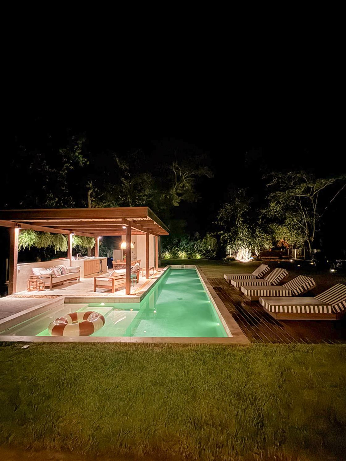 Pergolado e piscina iluminados à noite