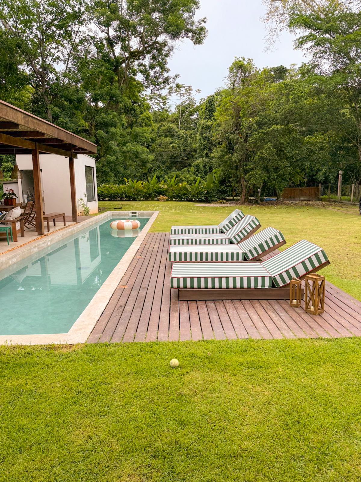 Deck com espreguiçadeiras ao lado da piscina
