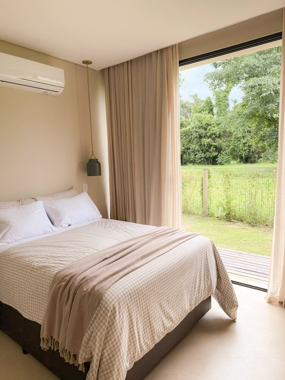Cama de casal na suíte gêmea, com janela para o jardim